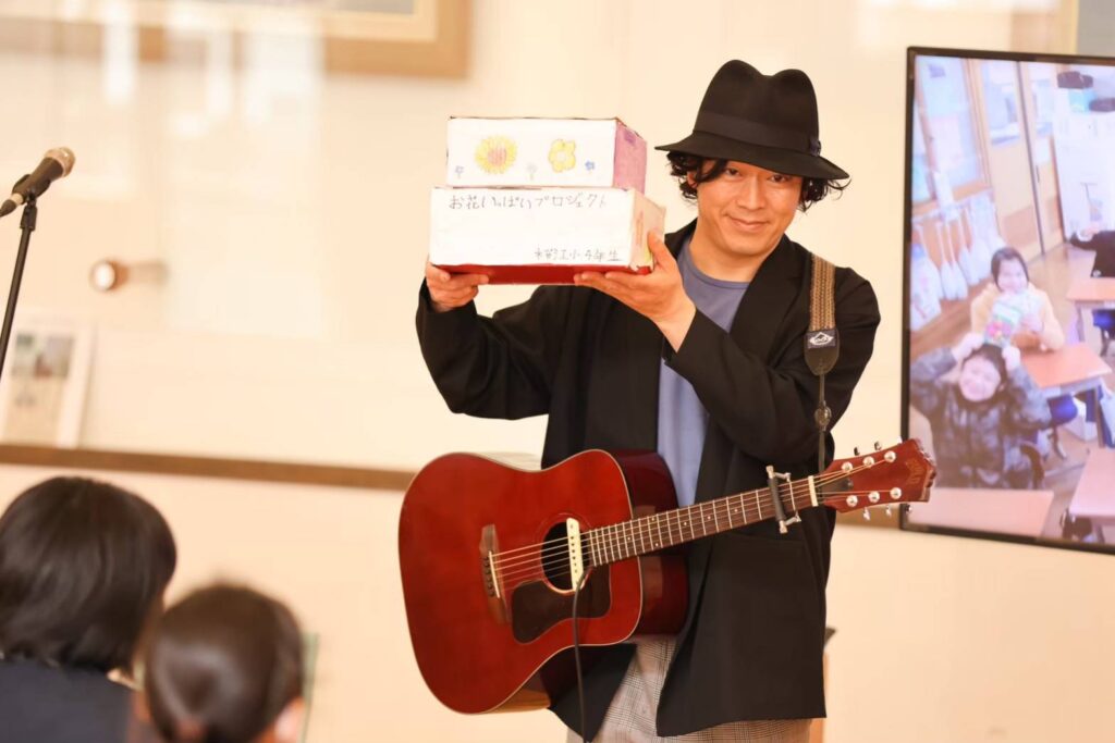 江津市桜江小学校で花の種を受け取るhactoさん