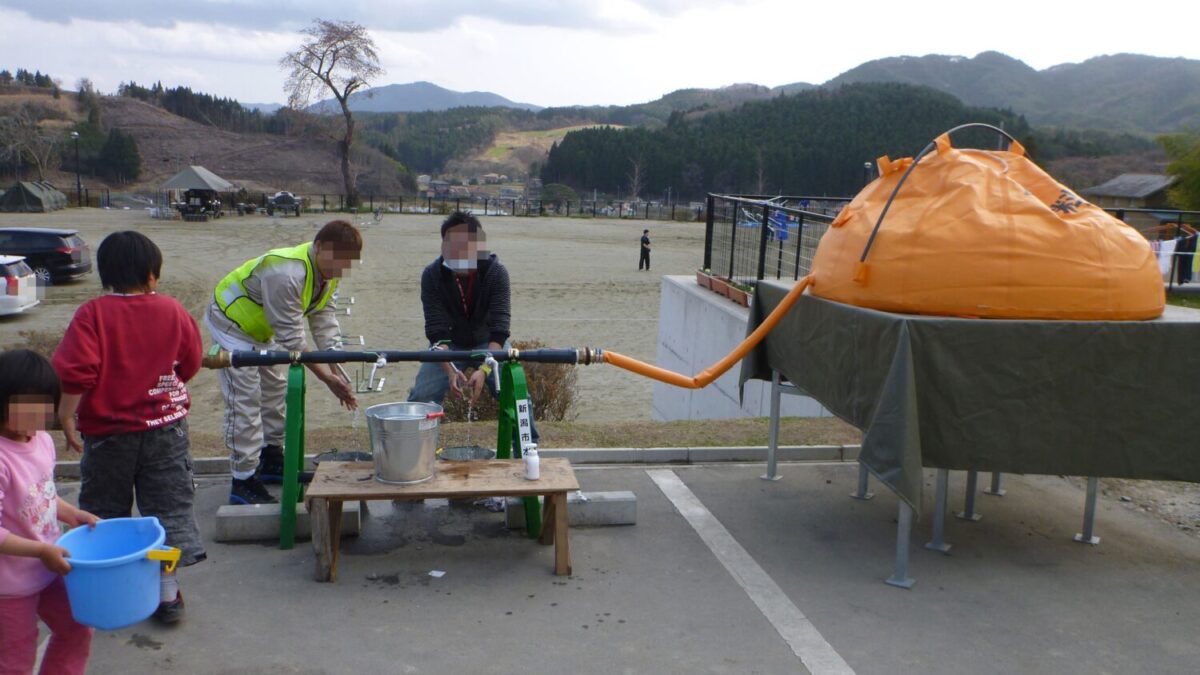 災害時は水が不足する（貴重な水で手を洗う被災者）