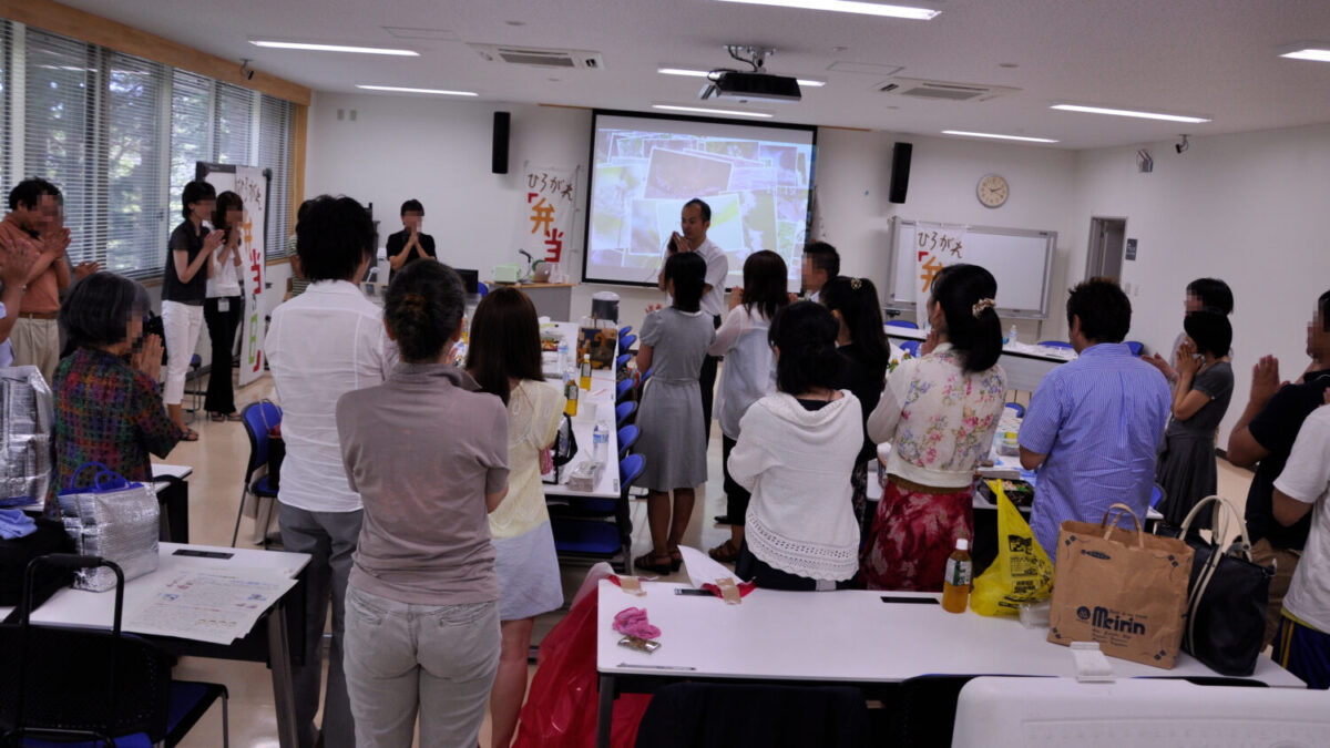 手作りの九州料理で被災地から来た生徒をもてなす交流会(参加者のほうを向いて、中央奥で司会をやっているのが太田秀人さん)=2012年8月(福岡県内)